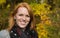 Natural red-haired young smiling woman in autumn on a walk.