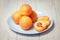 Natural ripe yellow apricots on porcelain plate sliced half with fruit pit