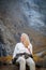 Natural Seclusion: A Girl on a Bridge by a Waterfall in the Mountains