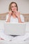 Natural shocked woman using laptop and phoning