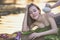 Natural Spa,Beautiful Woman relaxing in round outdoor bath with tropical flowers