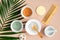 Natural SPA cosmetics for skincare, body and hair care. Top view facial clay masks, loofah, sponge, hair comb on peach background