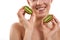 Natural spa. Portrait of young and happy attractive blonde woman with short haircut holding two pieces of kiwi and