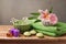 Natural spa and wellness concept with fresh towel, candles and flowers on wooden table over rustic grey background