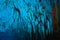 natural stalagmite or stalactite with blue led light in dark cave in mountain