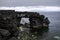 Natural stone arch of volcanic origin lava, on the coastline of the island of Pico, part of the Azores