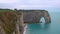 Natural stone arches, white chalk cliffs above English Channel, Etretat, France