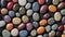 Natural stone background. Multicolored polished pebbles are tightly randomly stacked on a black background.