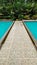 Natural stone floor by the poolside with light blue water