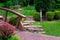 Natural stone path along flower bed near tile walkway.