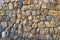 Natural stone wall background with irregular stones in shades of beige and grey