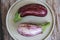 Natural striped eggplant fruits on a decorative plate