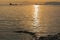 Natural summer sea sunset. Silhouettes of ships and strip of land on the horizon.