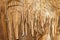 Natural texture image of nice natural cave with light brown walls and formations of stalagmites within - Marble Cave, Crimea