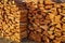 Natural texture of woodpile from coniferous trees. Pine firewood stacked on top of each other on a sunny day