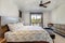 Natural tones cozy bedroom interior with grey bedding, beige carpet and lots of windows