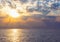 Natural tropical sundown on the sea with dramatic clouds. Sunset sky backlit by the sun over the ocean. Colorful rays reflected in