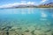 Natural turquoise Lake Tekapo and rocky edge