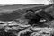 Natural view of huge rocks on a sloppy hill in grayscale