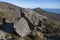 Natural view of two huge rocks on a sloppy mountain under a clear sky background