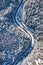 Natural winter landscape from air. Aerial view on the road and forest at the winter time. Winter chill. Forest and snow.