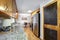 Natural wood cabinets in kitchen interior with island and black refrigerator