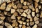 Natural wooden background, detailed chopped firewood. Woodpile of brown firewood, rough sawn trees with bark