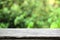 Natural wooden table in a rustic environment against a blured green background. Empty copy space