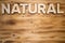 NATURAL word made with building blocks on wooden board