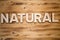 NATURAL word made with building blocks on wooden board