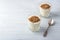 Natural yogurt with ground flax seeds in glasses on a light blue background