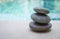 Natural Zen stone stack over blurred blue swimming pool background