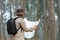 Naturalist looking at the map for direction while exploring wildlife in the pine forest for surveying and discovering the rare