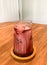 Naturally colorful iced red velvet latte on wooden plate