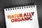 Naturally Organic - foods are grown without artificial pesticides, fertilizers, or herbicides, text concept on notepad