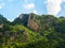 Nature background. Green jungle on the beautiful shape mountain on blue sky and fluffy cloud with sunshine on sunny day.