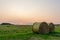 Nature background. Two bales of straw on foreground on the autumn meadow during wonderful sunset light