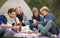 Nature, camping and friends on picnic with food laughing, talking and bonding on vacation. Happy, travel and group of