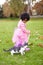 Nature, cat and girl playing in a garden on the grass on a summer weekend together. Happy, sunshine and portrait of