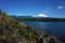 Nature of Chile, Beautiful landscape, Dark grey rocky coast lake Villarrica, snow capped Villarrica volcano