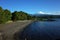 Nature of Chile, Beautiful landscape, Dark volcanic sand beach on Villarrica lake, snow capped Villarrica volcano, Pucon