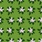 Nature flora seamless pattern with simple white daisy silhouettes on green background