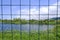 Nature in the open air behind bars or nets. Prison, slavery, cage, cage on the background of nature, trees and greenery