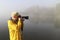 Nature photographer in action on fogy dawn
