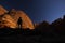 Nature photographer on a hiking trip at the Australian outback between dome of rocks as shadow play