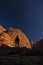 Nature photographer on a hiking trip at the Australian outback between dome of rocks as shadow play with blue sky