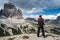 Nature photographer tourist with camera shoots while standing Italy Dolomites Alps