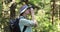 Nature photography - woman photographer taking picture of with analog film camera in forest