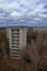 Nature reclaims its space around two empty, worn buildings