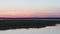 Nature of Russia: bird island at sunset, flight of seagulls against a pink sky, aerial view